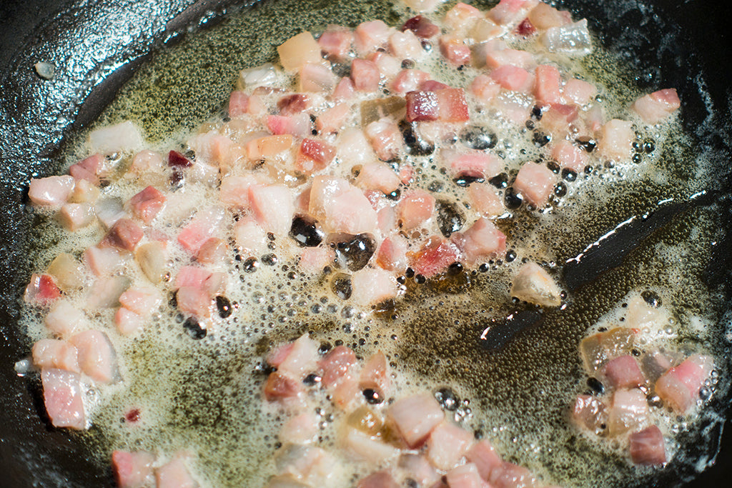 Zerlassene Butter und Speck in der Pfanne