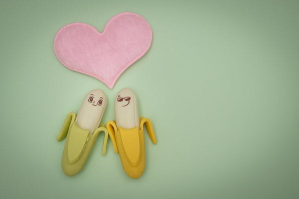 2 Bananas in love, green background, pink love heart