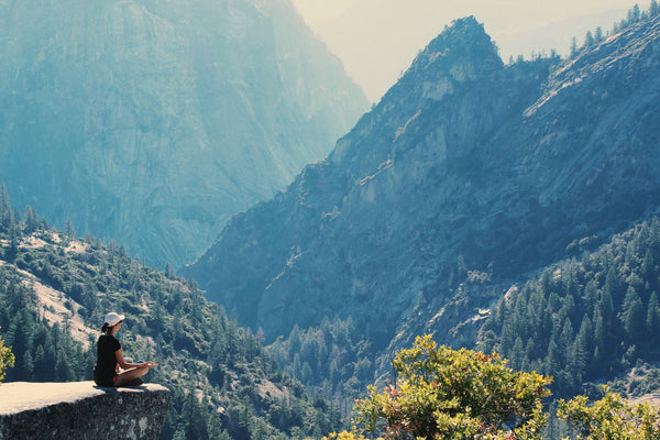 Lady meditating on mountain