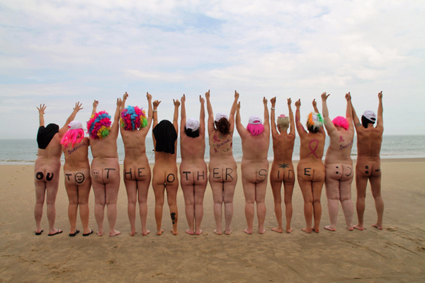Line of naked women showing off their bums on a nudist beach