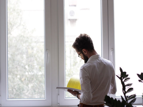 5 Ways to Get Noticed At Work  - man stood next to window at work