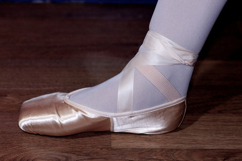 Pointe shoe with ribbon and elastic sewn