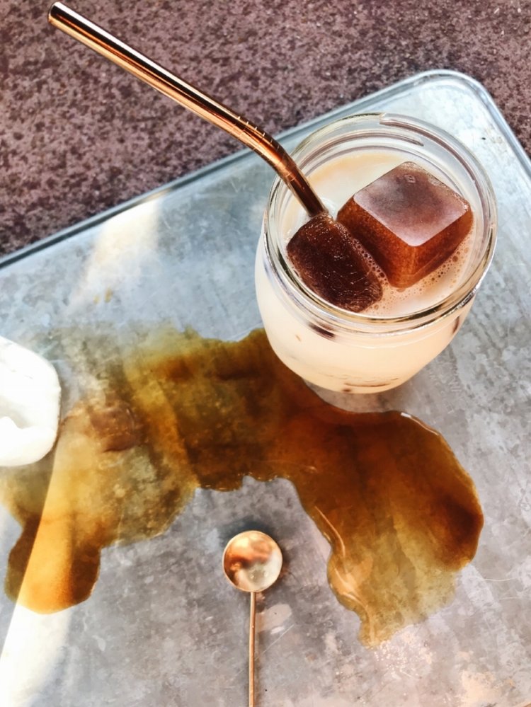 Big Heart Tea Co.'s organic herbal tea Fake Coffee as ice cubes, with reusable straw, reusable cup, and reusable gold spoon