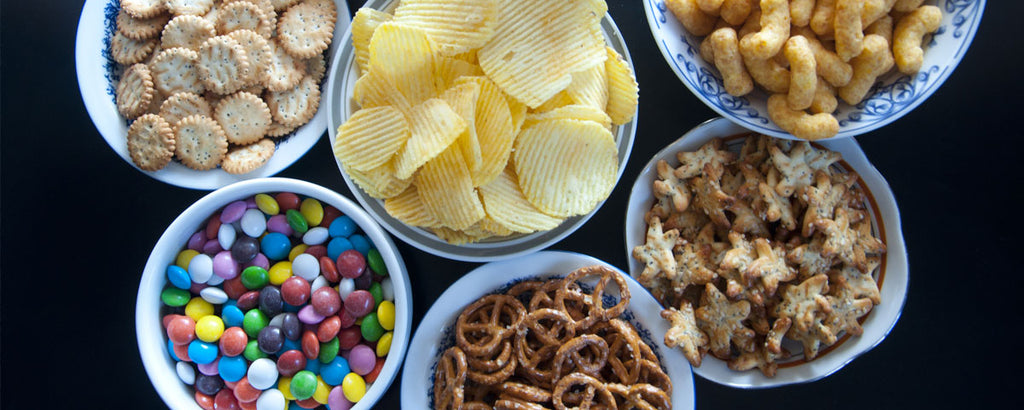 Dishes of candy, chips, and other processed foods