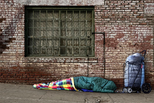 Homeless man sleeping on the street showcasing the homeless crisis in LA
