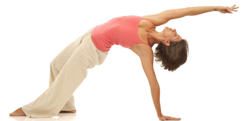 Female doing backward yoga bend white background