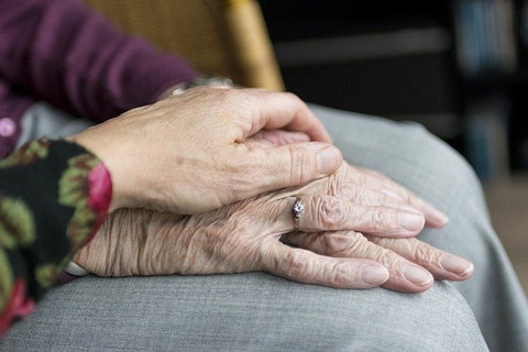 old wrinkled hands of a couple clasped together