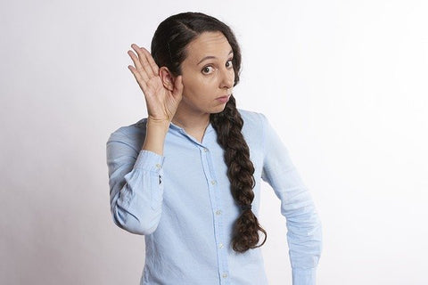 Woman indicating she can't hear