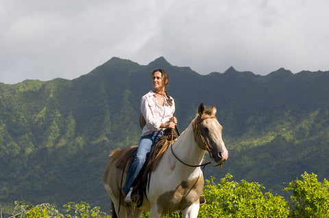 woman riding a horse in mountains
