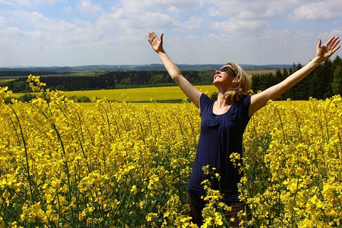 happy woman standing in flowers