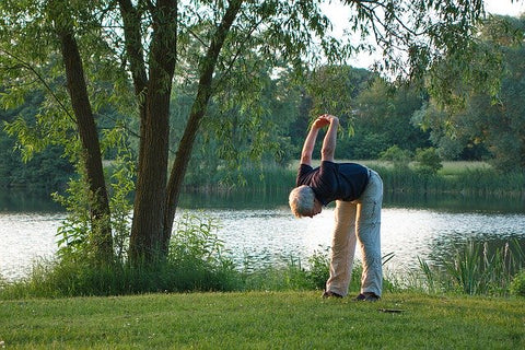 Man stretching by a lake