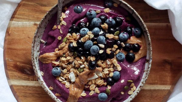 birds eye view of an acai berry smoothie bowl topped with fruit