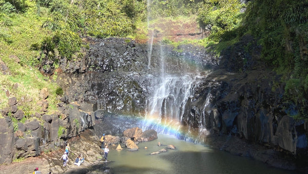 rainbow created at the base of a waterfall
