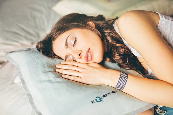 Woman sleeping with Blisslets nausea bands for improved sleep