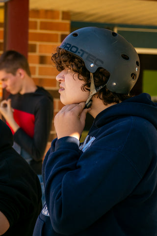Kid Putting on Skateboard Helmet