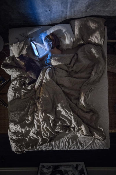 child with ipad in bed