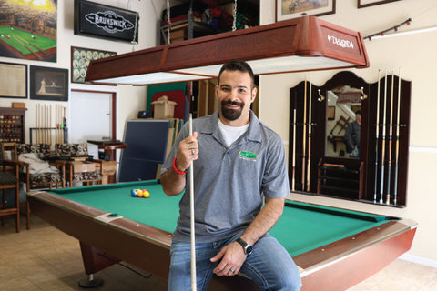 Juston Markell taking a candid shot during a game of pool at his shop in Michigan