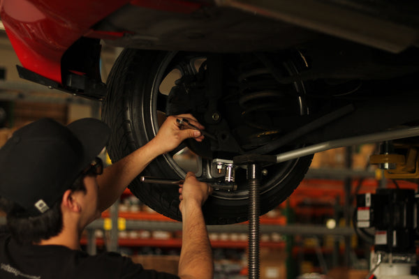 Mechanic installing rear anti-roll bar on Ford Fiesta ST 