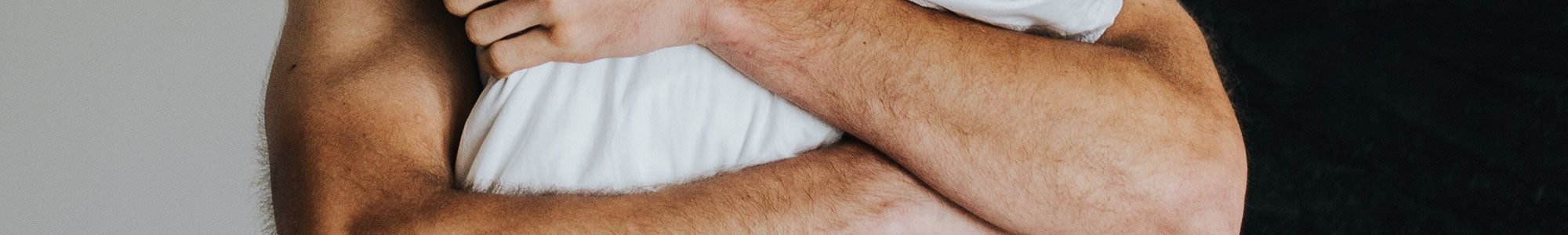 Man in underwear holding a pillow suffering from erectile dysfunction