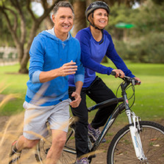 Man jogging and woman cycling in the park.