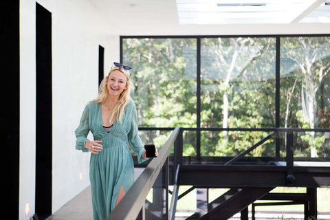 Smiling blonde woman in a house with tall windows