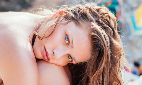 Blue-eyed woman on the beach with wet hair