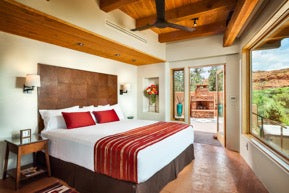Desert-inspired bedroom with exposed wood and red accents
