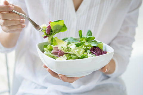 Woman eating organic green salad