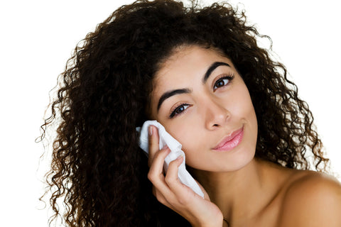 Beautiful olive skinned woman with curly hair using Ogee Organic Daily Facial Cleansing Cloth