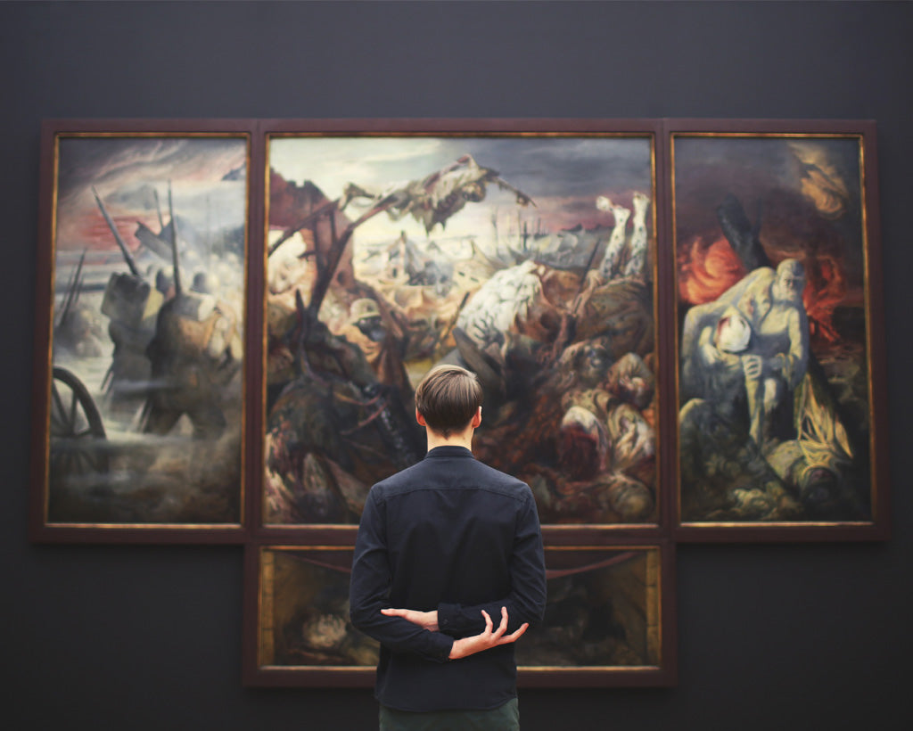 Man kijkt naar schilderijen in de galerie