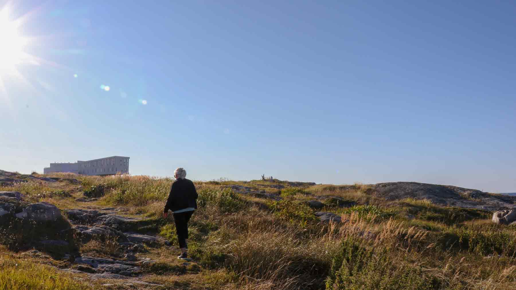 The Asmuss founder's Mum walking up a hill into the sun on Fogo Island