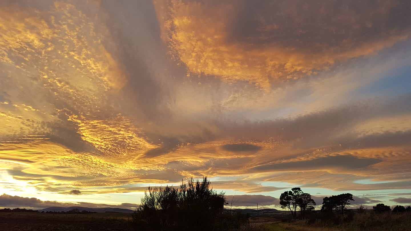 The last rays of sun as golden clouds above Kinnesswood