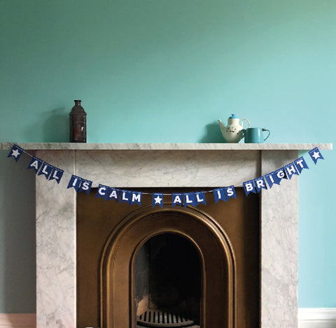all is calm paper bunting by hiya pal on blue wall with fireplace