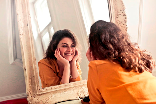 Woman smiling at herself in the mirror