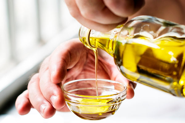 Pouring castor oil in a small glass bowl