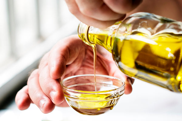 Pouring castor oil in a small glass bowl