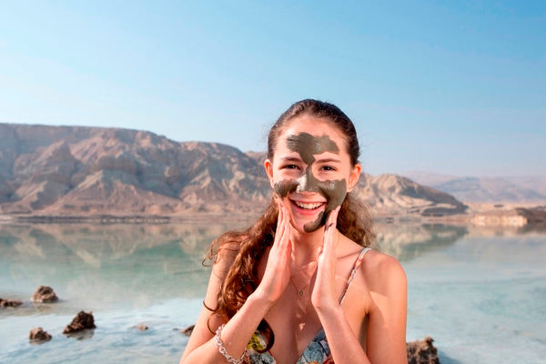 Applying mud mask to face