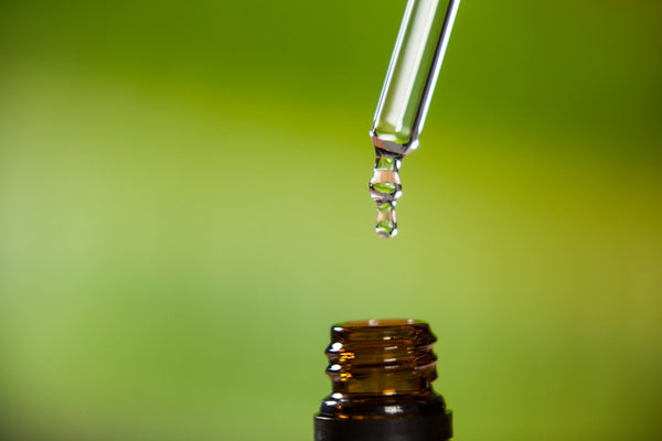 Essential oil in glass dropper and amber glass bottle