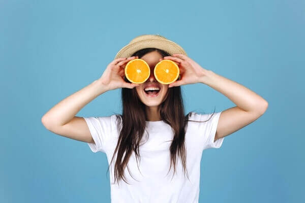 Woman holding two orange slices