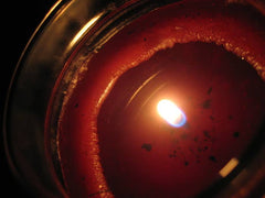 Lit red candle with tunnelling