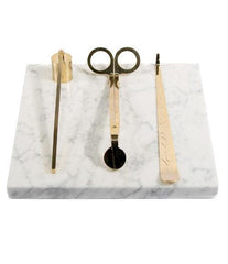 Gold wick trimmer, snuffer and leveller on square marble plate