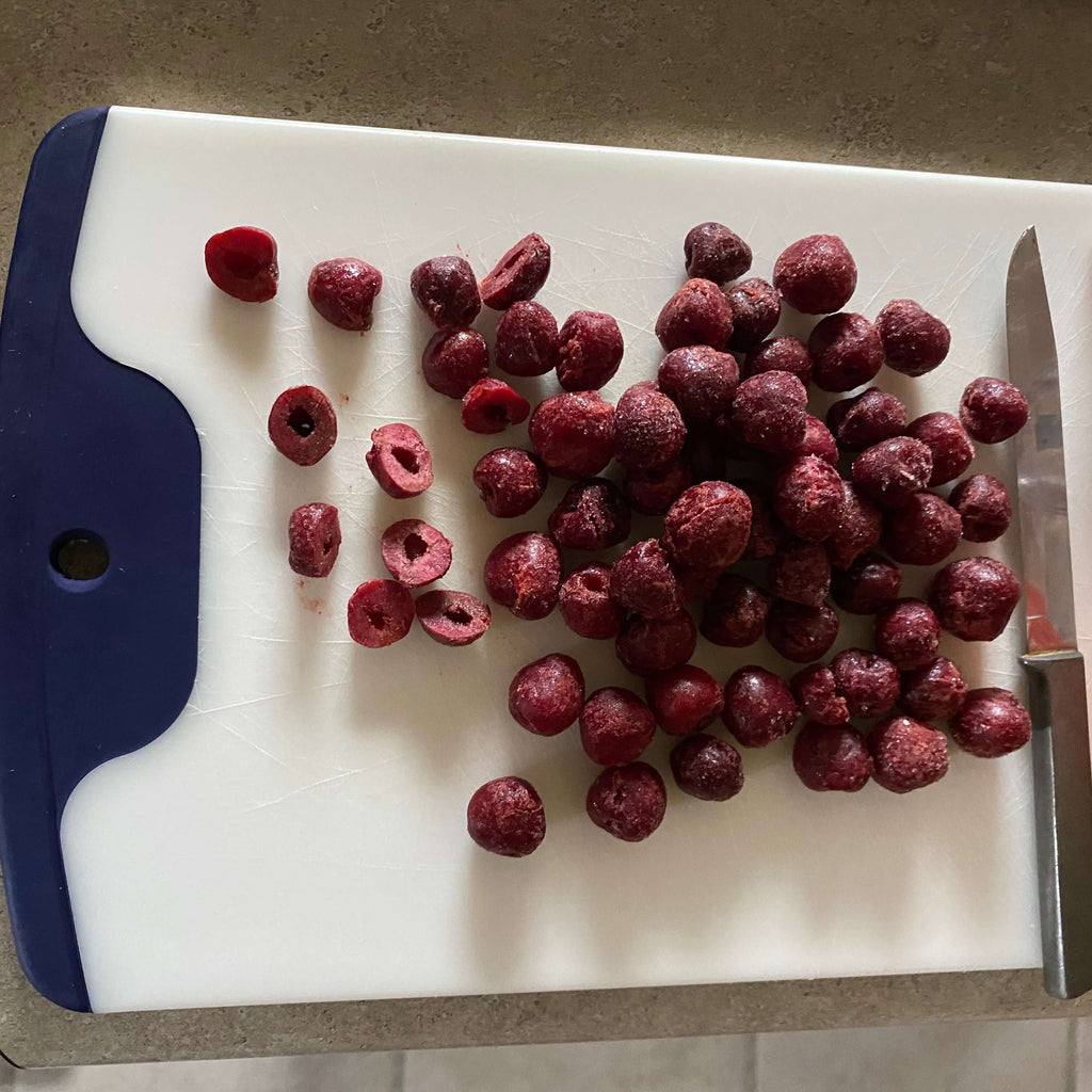 Cutting board and frozen pitted cherries for Greek Yogart and  Cherry Healthy Snack