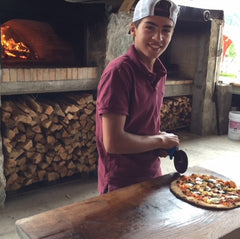 Chase slicing wood-fired pizza