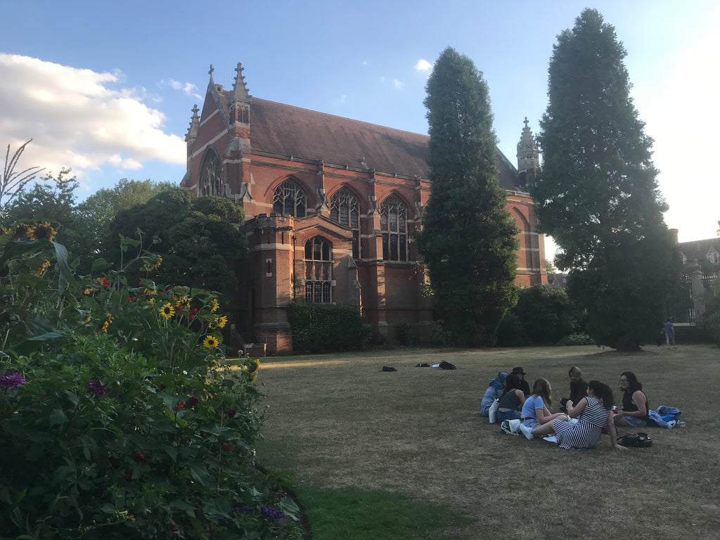 Oxbridge students relaxing on the grass after class.