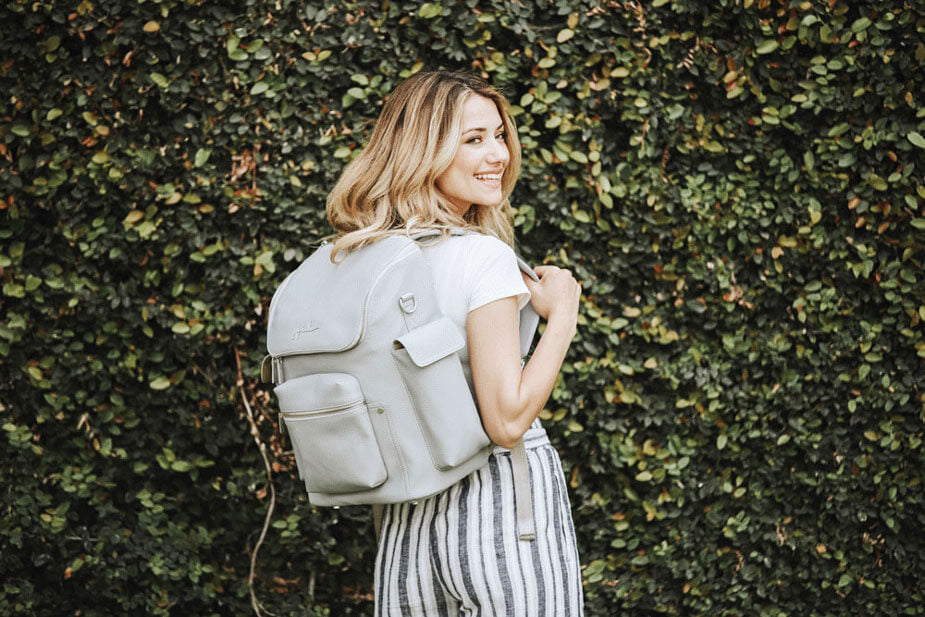 Woman poses with her white, JuJuBe backpack