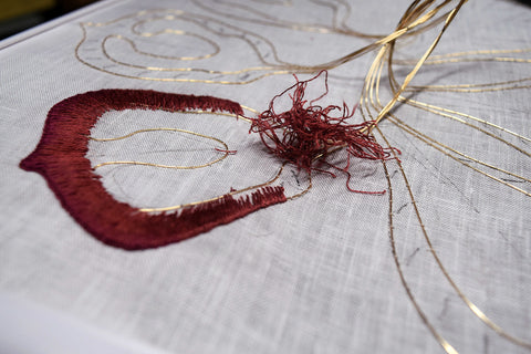 Tearing out progress on a stumpwork petal with knot of threads