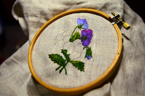 Purple pansy embroidered design unfinished in hoop - leaves and small flowers complete