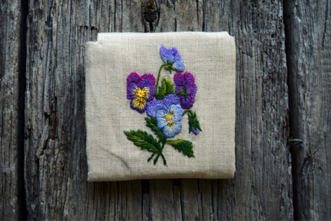 Back of business card case hand embroidered with blue and purple pansies