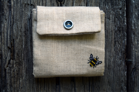 Front of business card case with button snap and embroidered bee in corner