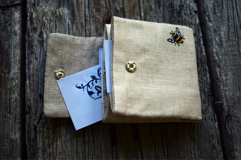 Open business card case with cards, showing embroidered bee